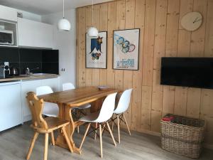 cocina y comedor con mesa de madera y sillas en Appartement 1 chambre, 4 personnes, en Champagny-en-Vanoise