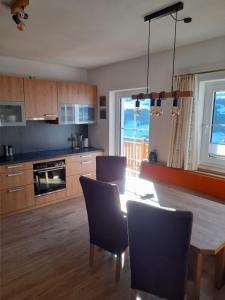 eine Küche mit einem Tisch und Stühlen sowie ein Esszimmer in der Unterkunft Appartement Döringerhof in Aich