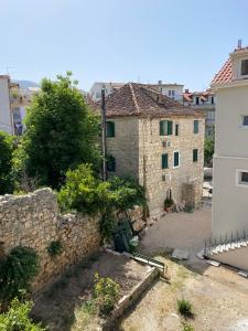 an old building with a stone wall next to a building at Apartman Karla in Makarska