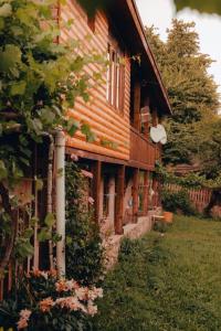 an old wooden house with trees and flowers at Teo Guesthouse and Camping in Mestia in Mestia