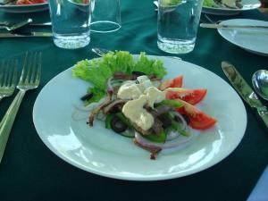 un plato blanco con una ensalada en una mesa en Explorer by Eco Team - Dambana, en Dumbana