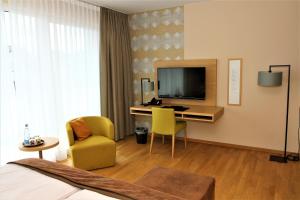 Zimmer mit einem Schreibtisch und einem TV in der Unterkunft Restaurant & Hotel Einhorn in Oppenweiler
