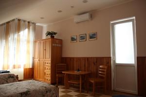 a bedroom with a bed and a table and a window at Alma B&B in Kalvarija