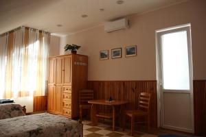 Schlafzimmer mit einem Bett, einem Tisch und einem Fenster in der Unterkunft Alma B&B in Kalvarija