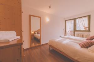 une chambre avec un grand lit et un miroir dans l'établissement RTA Torre Del Brenta, à Madonna di Campiglio