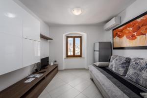 a living room with a couch and a refrigerator at Apartments Dante in Umag