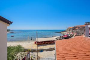 a view of a beach with a building and the ocean at Apartments Dante in Umag