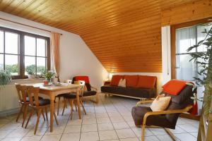 a living room with a table and a couch at Hof Wagenberg Ferienwohnung 2 in Deggenhausertal