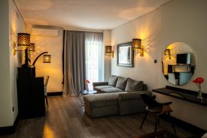 a living room with a couch and a mirror at Athenian Riviera Hotel& Suites in Athens