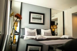 a bedroom with a bed with a mirror at Athenian Riviera Hotel& Suites in Athens