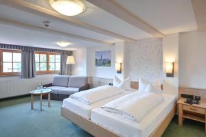 ein Hotelzimmer mit einem großen Bett und einem Sofa in der Unterkunft Hotel Helmer in Schwangau