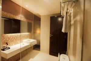 a bathroom with a sink and a toilet and a mirror at Mercure Padang in Padang