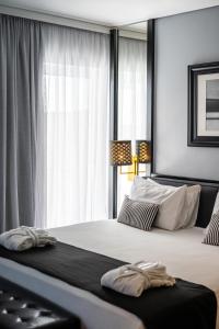 a bedroom with a large bed with a window at Athenian Riviera Hotel& Suites in Athens