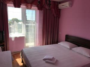 1 dormitorio con ventana grande y 1 cama con 2 toallas en AVRORA, en Zatoka