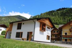 um grupo de edifícios com montanhas ao fundo em Chalet Tolder em San Candido