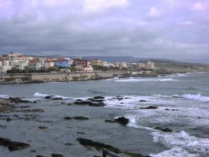 vistas a una playa con olas y edificios en B&B Valli Verdi, en Alghero