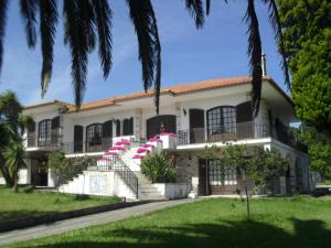 a house with pink umbrellas in front of it at Apartamentos na Casa São Bernardo in Alcobaça