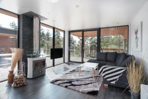 a living room with a couch and a fireplace at Seija's Modern Secluded Villa with Jacuzzi & Sauna in Töfsala