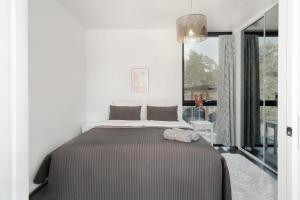 a bedroom with a bed and a large window at Seija's Modern Secluded Villa with Jacuzzi & Sauna in Töfsala