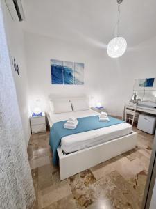 a white bedroom with a bed and a sink at Albatros B&B Porto Cesareo in Porto Cesareo