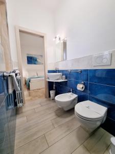 a blue and white bathroom with a toilet and a sink at Albatros B&B Porto Cesareo in Porto Cesareo