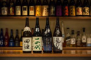 una fila de botellas de vino sentadas en un estante en Hotel Sunrise Inn en Kaizuka