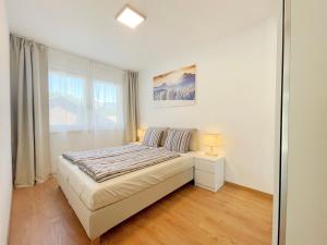 
a bedroom with a white bed and white walls at Apartments ALPsmart in Oetz
