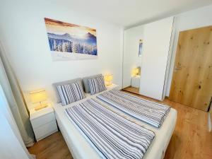 
a bedroom with a bed, a desk, and a painting on the wall at Apartments ALPsmart in Oetz
