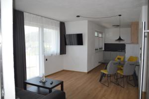 salon ze stołem i żółtymi krzesłami w obiekcie Apart Bergsonne w mieście Fiss