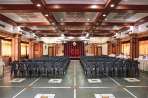 an empty hall with chairs and tables in it at Hotel Shreyas in Pune