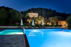 a swimming pool at night with a hotel in the background at Julia Hotel in Fourka