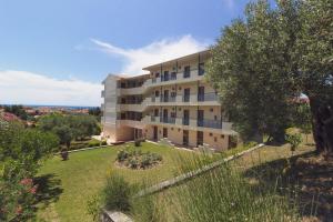 an apartment building on a hill with a garden at Julia Hotel in Fourka