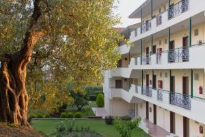 an apartment building with a tree in the foreground at Julia Hotel in Fourka
