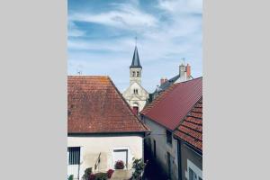 Blick auf eine Stadt mit Kirche und Dächern in der Unterkunft Bel appartement indépendant centre de Magny-Cours avec parking in Magny-Cours