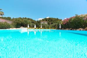 a large pool of blue water with chairs and umbrellas at Julia Hotel in Fourka