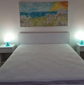 ファヴィニャーナにあるIl sentiero delle aloeのベッドルーム1室(白いベッド1台、ランプ2つ付)