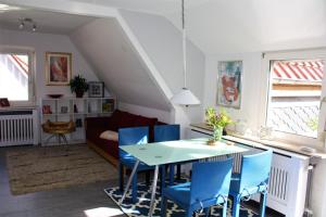 - un salon avec une table et des chaises bleues dans l'établissement Ferienwohnung Heimelich, à Rastede