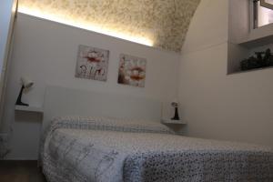 a bedroom with a bed with three pictures on the wall at Casetta Bevilacqua in Sciacca +3 photos