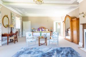 a bedroom with a bed with blue chairs and a table at The South Wing in Salisbury