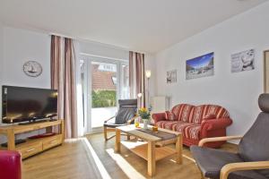 un salon avec un canapé et une télévision dans l'établissement FeWo am Hochzeitsberg FeWo 01 - Terrasse, à Breege