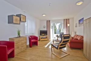 un salon avec un canapé et une chaise dans l'établissement FeWo am Hochzeitsberg FeWo 01 - Terrasse, à Breege