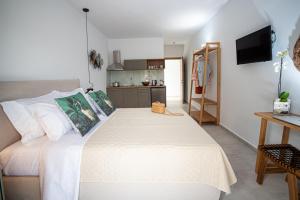 a bedroom with a large white bed and a kitchen at OLEA Luxury Apartments in Parga
