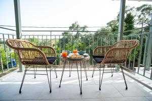 2 sedie e un tavolo con un piatto di cibo sul balcone di OLEA Luxury Apartments a Párga