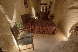 a bedroom with a bed and a chair in a room at B&B Fiorentini in Matera