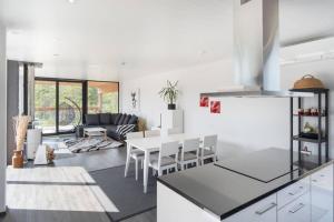 Seija's Modern Villa with Hot tub في Töfsala: مطبخ وغرفة معيشة مع طاولة وكراسي