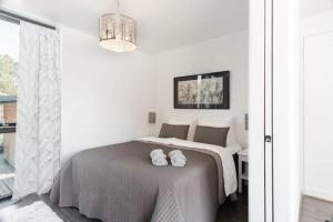 1 dormitorio con 1 cama con 2 toallas en Seija's Modern Villa with Hot tub, en Töfsala