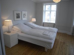 a bedroom with a bed with white sheets and a window at Nyborggade in Copenhagen