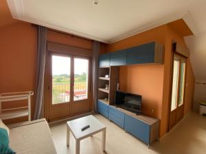 a living room with a couch and a tv at Las Catedrales in Barreiros