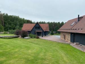 a house with a grass yard and a building at Lättemaa in Raanitsa