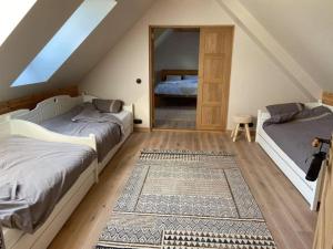 a attic bedroom with two beds and a mirror at Lättemaa in Raanitsa